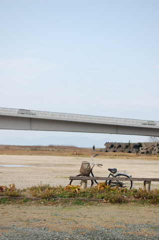 河川敷にあるベンチと自転車の写真です
