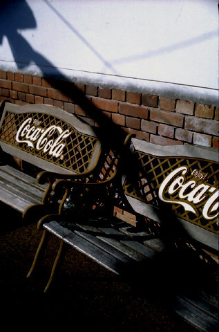 コカコーラのロゴの入ったレトロなベンチの写真です